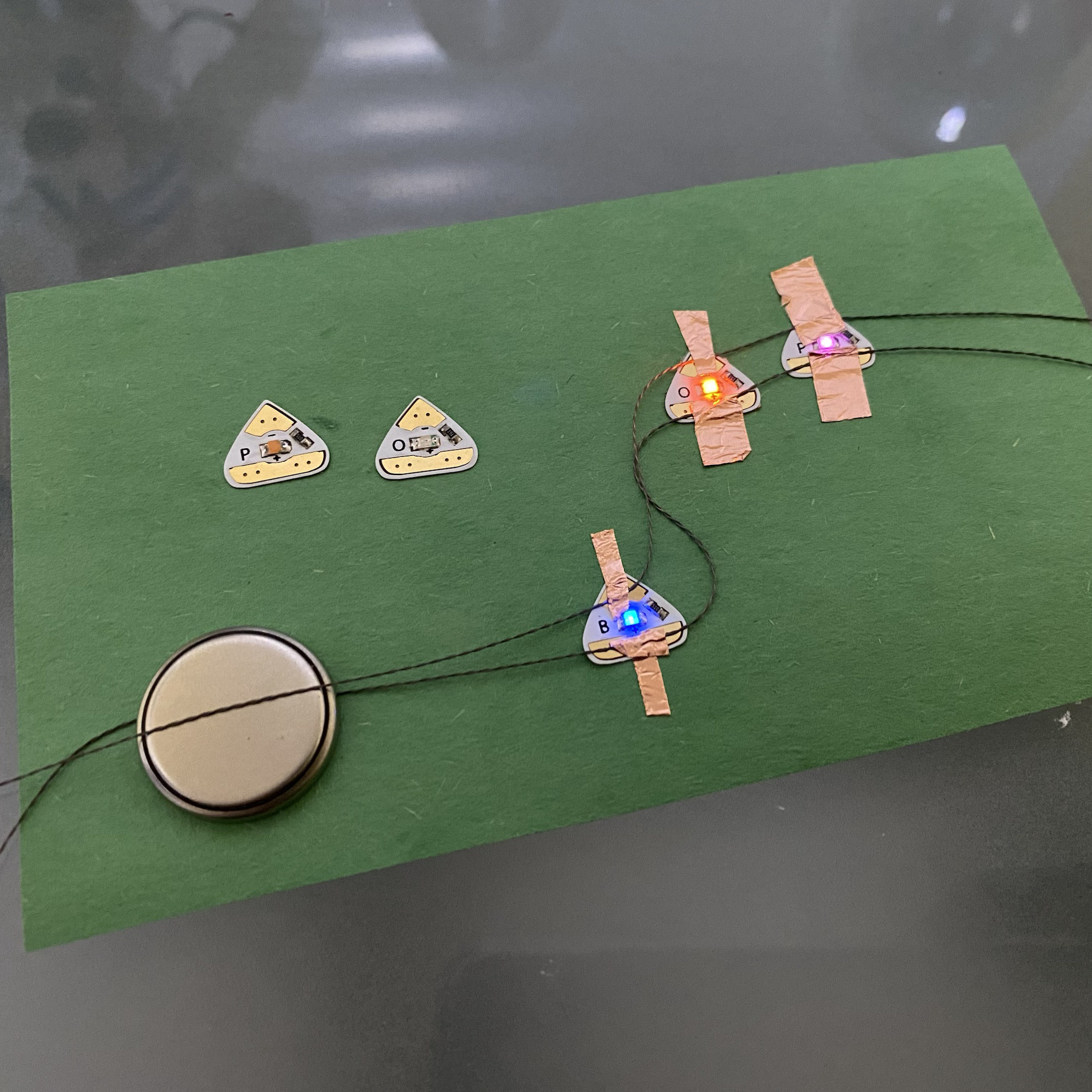 I wanted to begin experimenting with more than one LED being lit up, but hidden. I decided on beads/jewels. This is the first iteration of what was underneath the drawing. I had to make sure the first side lit up before I continued.